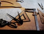 A collection of cartographer's tools on a table with maps.